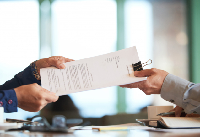 closeup-de-maos-passando-o-contrato-ao-empresario-irreconhecivel